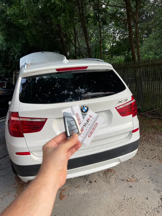 A new BMW smart key at a white BMW X3