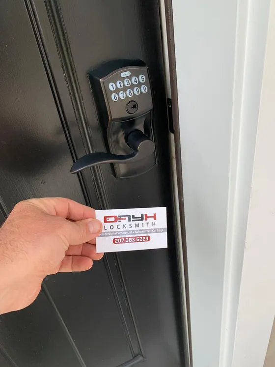 A keypad deadbolt on a dark front door, with an Onyx card