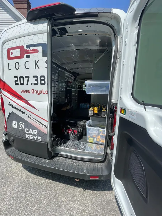 The back of an Onyx van, fitted out as a workshop with shelves of parts